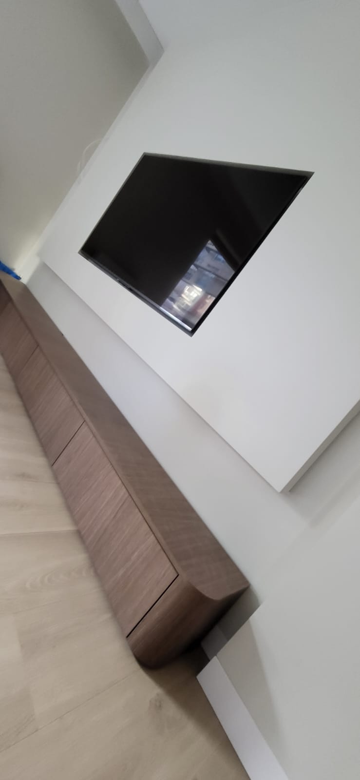 Zwevend walnoten tv-meubel met verzonken scherm in gestucte wand