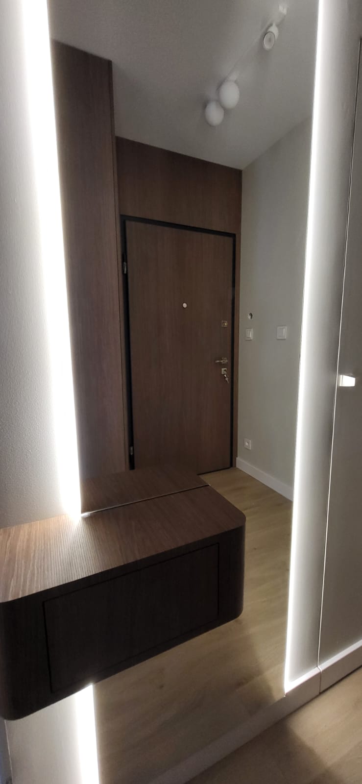 Entreehal met verlichte spiegelpanelen en walnoten console