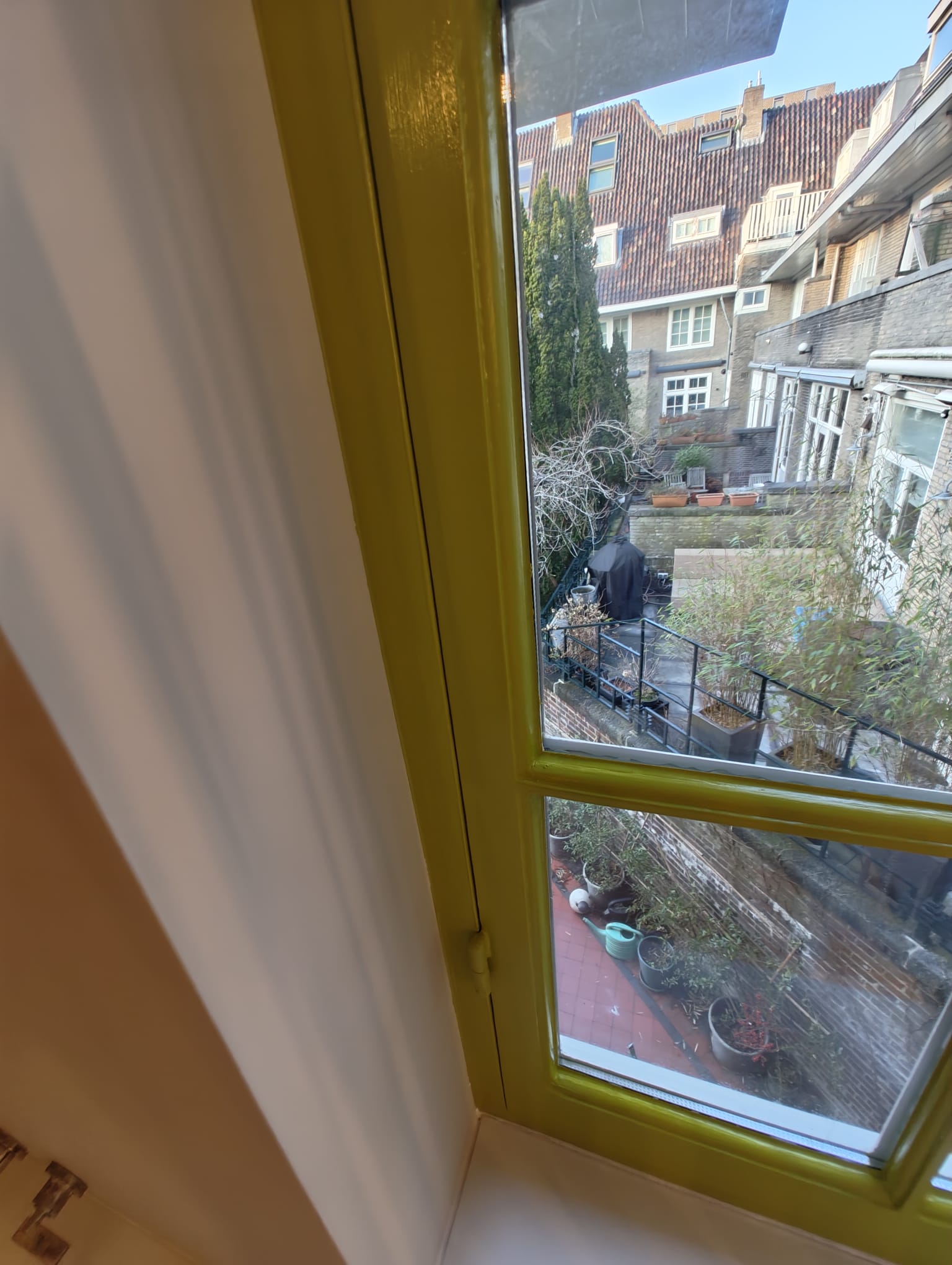 Gerestaureerd Amsterdams grachtenpand raam met geel geschilderd kozijn