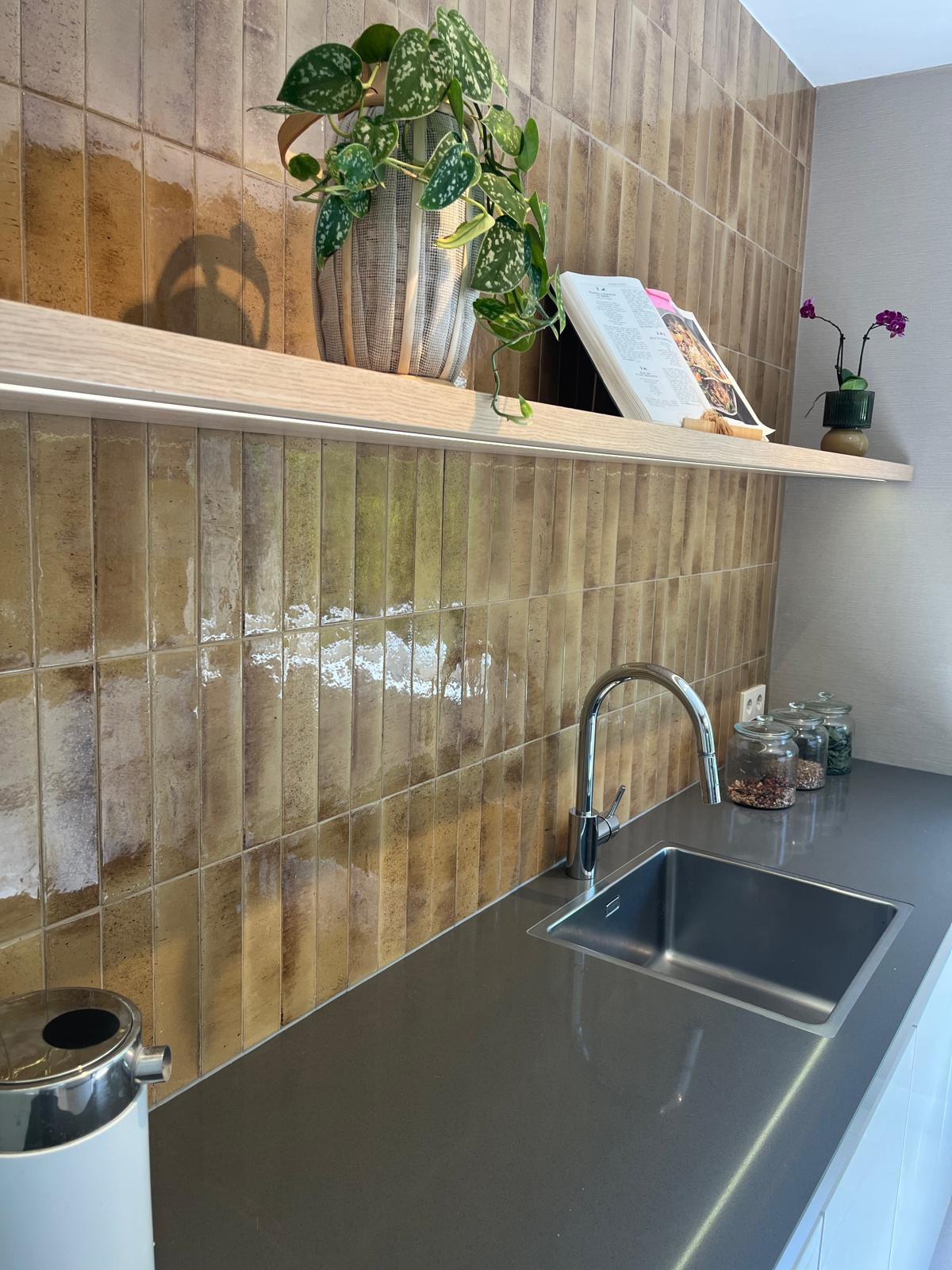 Keukenwasbak met LED-verlichte plank en glazuur tegelwand