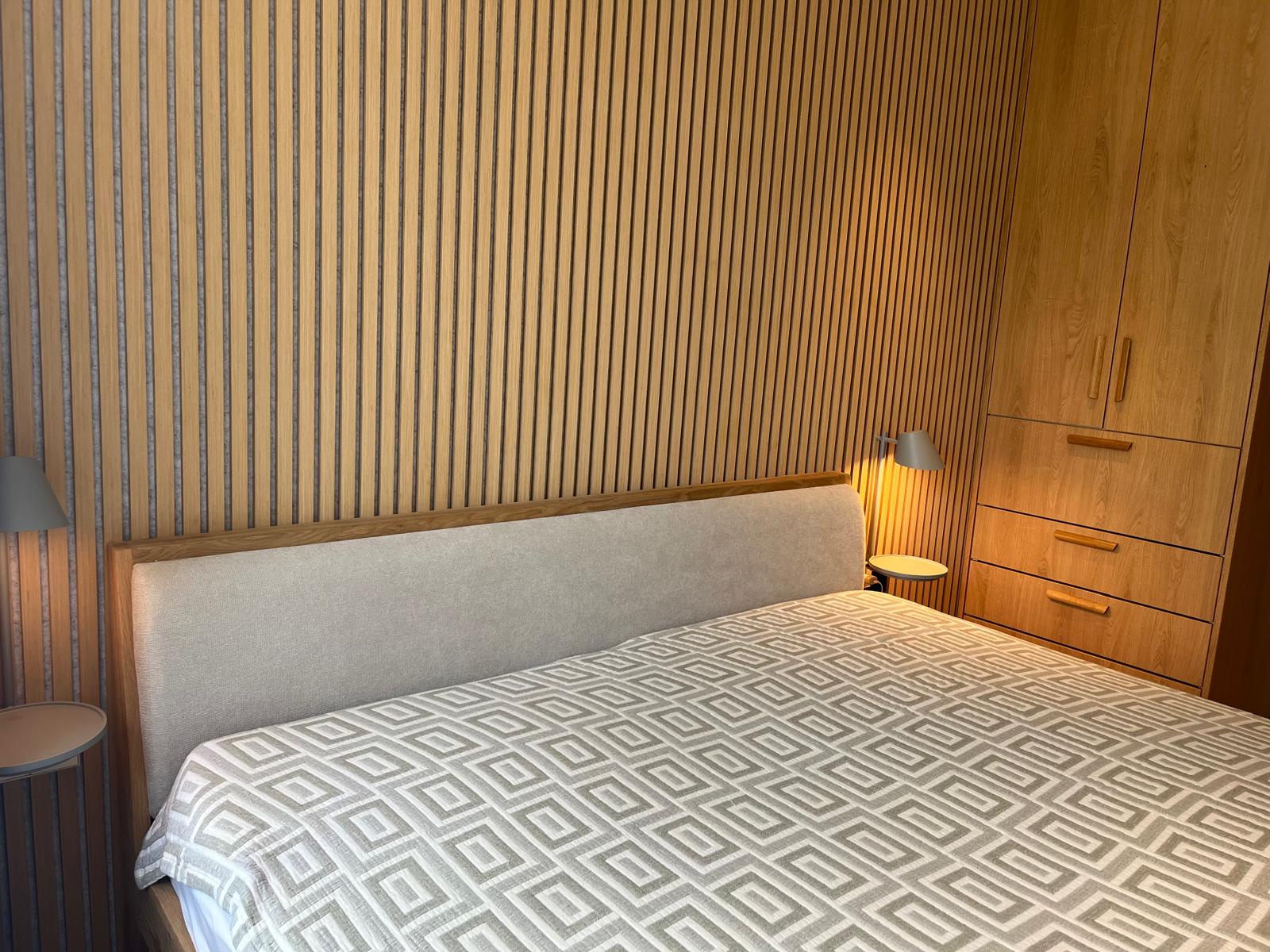 Slaapkamer met latten accentwand en ingebouwde eiken kast
