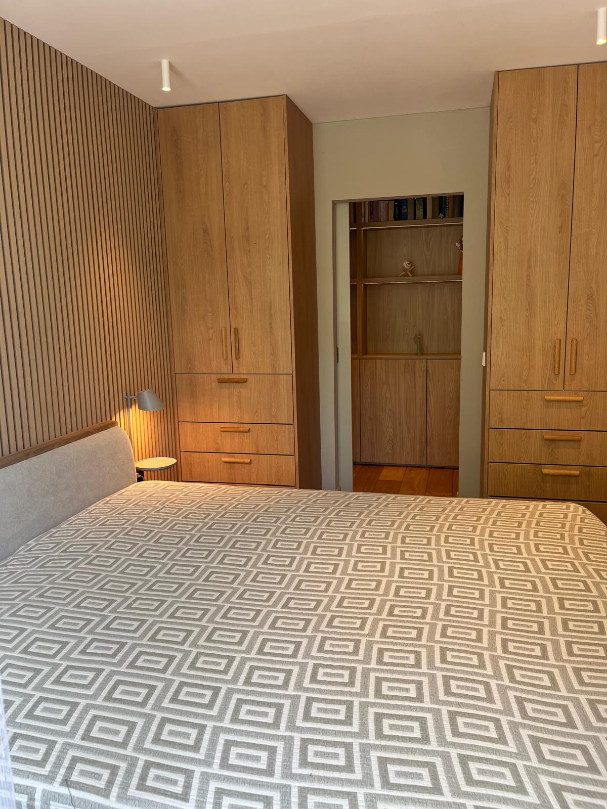 Hoofdslaapkamer met kastenparen en latten accentwand