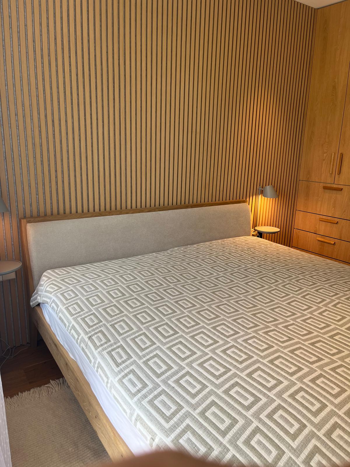 Slaapkameroverzicht met eiken bed, kast en leeslampen